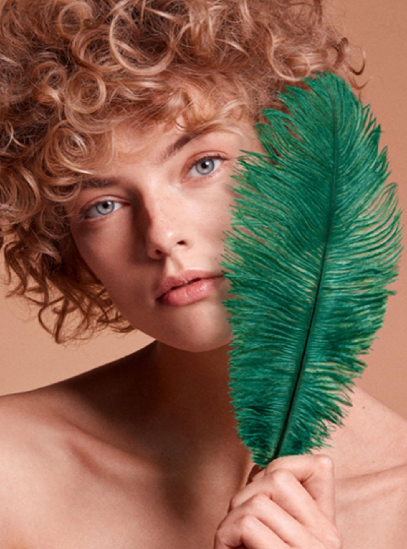 Image of woman holding a teal feather